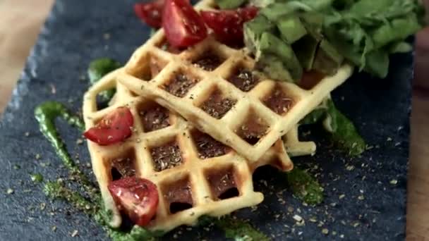 Fresh baked Belgian waffles with arugula, tomatoes and avocado on black a plate. Savory waffles. Breakfast concept. Healthy breakfast - Filmati, video