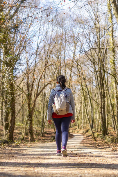 Sporty Spanish woman walking on the pathway in the forest in springtime, Garrotxa Volcanic Zone Natural Park - Foto, immagini