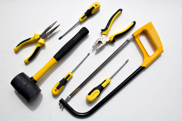 Set of black and yellow working tools, pliers, wire cutters,screwdrivers, hammer and saw which can be used to repair, build, improve, fix by carpenter, repairman, mechanic, handyman - Photo, Image
