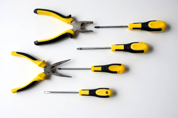Black and yellow working tools, pliers and wire cutters. Competition, fight, combat, battle, aggressive - Photo, Image