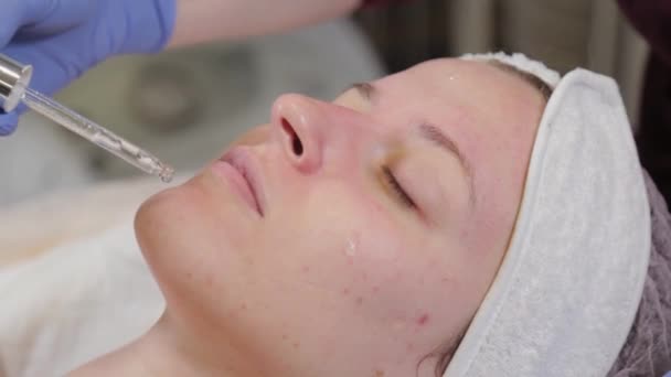 Profi kozmetikus alkalmazni szérum egy pipetta az arcra. - Felvétel, videó