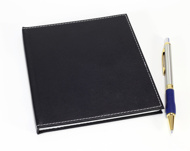 Black note book and pen on white background - Foto, imagen