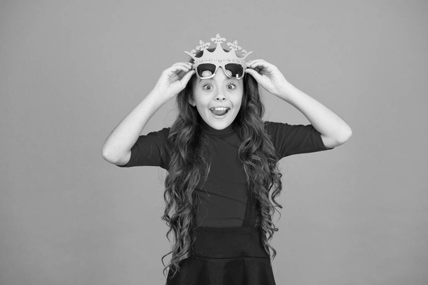Wow Im surprised. Surprised kid wear prop crown and glasses. Little child look surprised orange background. Small girl keep mouth open with surprise. Being surprised. School prom. Party celebration - Photo, Image