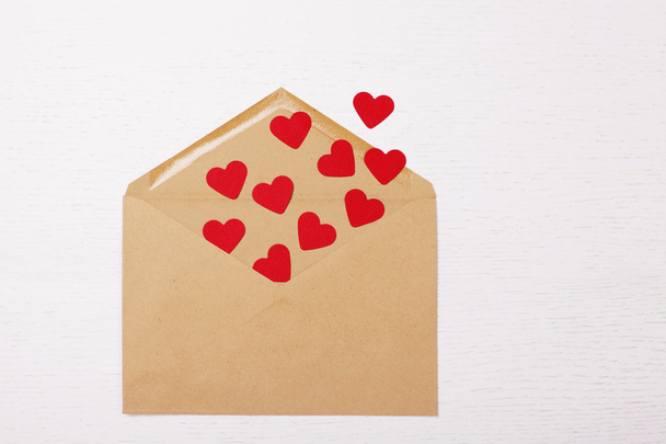 brown envelope with red paper hearts inside - Φωτογραφία, εικόνα