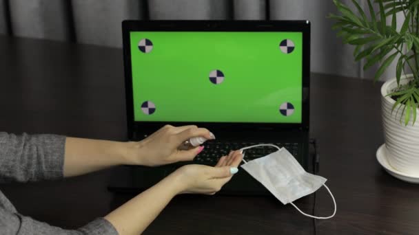 Женские руки используют дезинфицирующее средство рядом с ноутбуком с зеленым экраном. Коронавирус
 - Кадры, видео
