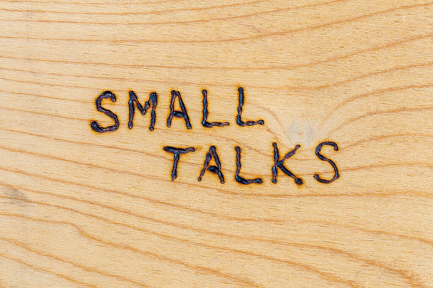 as palavras small talks manuscritas com woodburner na superfície plana da madeira compensada na perspectiva diretamente acima
 - Foto, Imagem