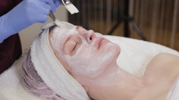 Професійний косметолог наносить маску для обличчя жінці
. - Кадри, відео