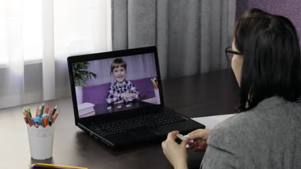 Woman teacher makes video call on laptop with children pupil. Distance education - Footage, Video