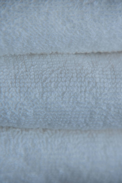Weiße Handtücher. Schön aufeinander abgestimmte saubere oder neue Handtücher auf dem Tisch. Konzept des Schönheitssalons Sauberkeit im Hotel - Foto, Bild