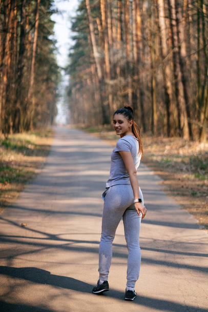 Fitness mladá žena procházky v parku a pózování pro kameru - Fotografie, Obrázek
