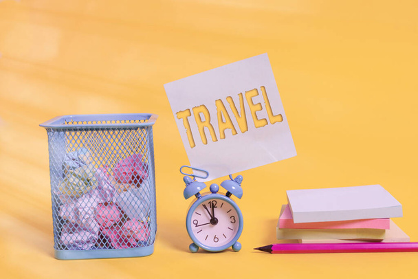 Writing note showing Travel. Business photo showcasing the movement of showing between distant geographical locations Alarm clock pencil note paper balls container pads colored background. - Photo, Image