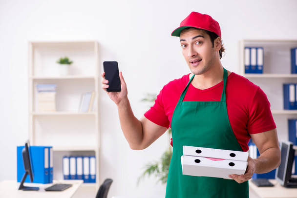Jovem mensageiro masculino entregando pizza para o escritório - Foto, Imagem