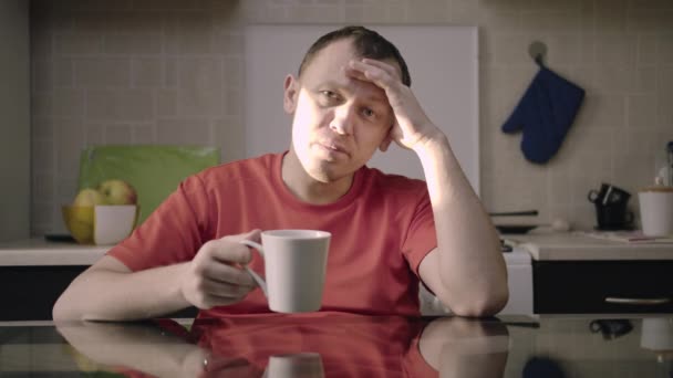 Портрет молодого чоловіка з чашкою гарячого напою, що сидить за столом
 - Кадри, відео
