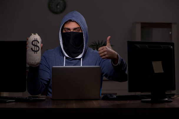 Hombre hacker piratería firewall de seguridad tarde en la oficina - Foto, imagen