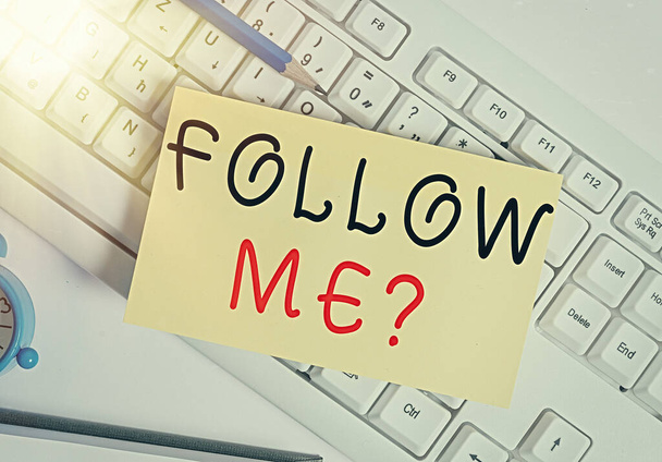 Writing note showing Follow Me Question. Business photo showcasing go or come after an individual or thing proceeding ahead White pc keyboard note paper and paper clips above white background. - Photo, Image
