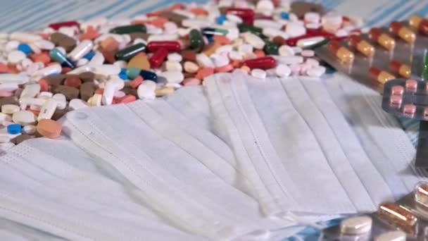Weiße medizinische Masken und Pillen rotieren. Medikamente auf dem Tisch. Arzneimittel im Gesundheitswesen. Das Konzept der Erfindung von Medikamenten aus COVID-19 - Filmmaterial, Video