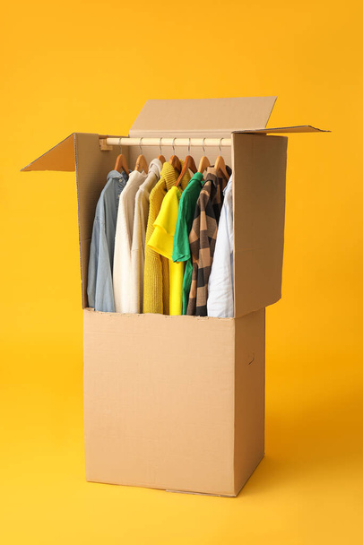 Pohyblivý box s oblečením na barevném pozadí - Fotografie, Obrázek