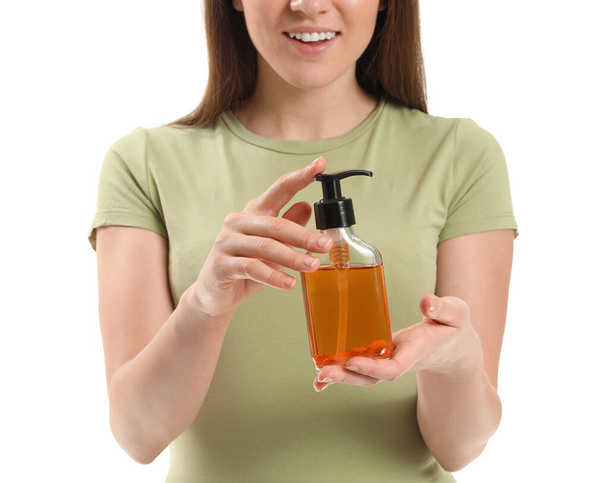 Junge Frau mit Kosmetik in der Flasche auf weißem Hintergrund - Foto, Bild