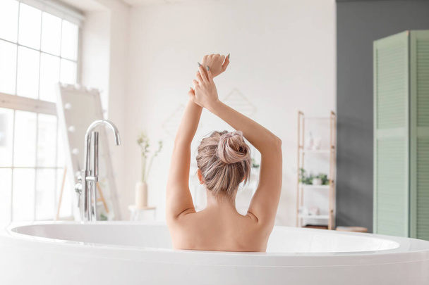 Beautiful young woman taking bath at home - 写真・画像
