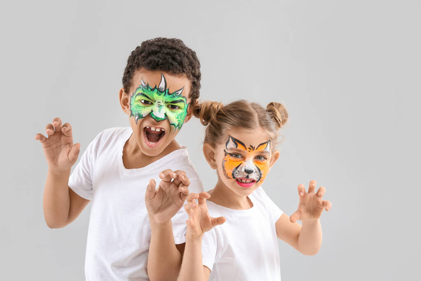 Vtipné děti s obličejovou malbou na světlém pozadí - Fotografie, Obrázek