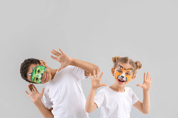 Funny children with face painting on light background - Photo, Image