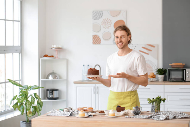 Miespuolinen makeinen maukkaalla jälkiruoalla keittiössä
 - Valokuva, kuva