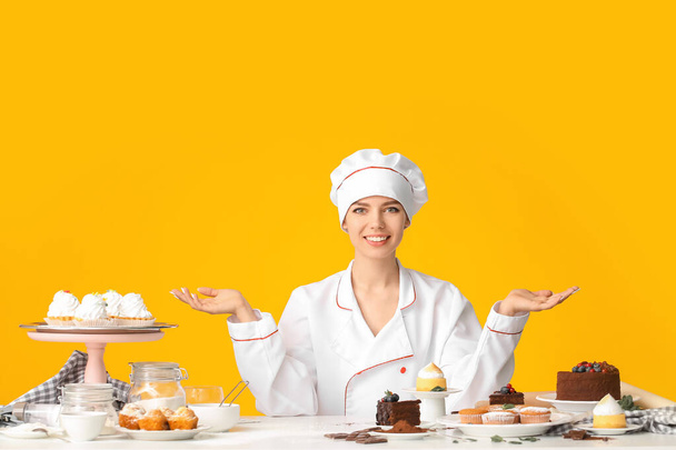 Kobieta cukiernik z smacznych deserów na tle koloru - Zdjęcie, obraz