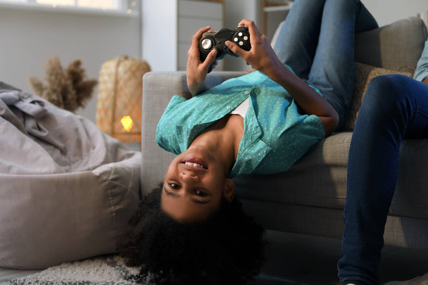 Adolescentes afroamericanos jugando videojuegos en casa
 - Foto, imagen
