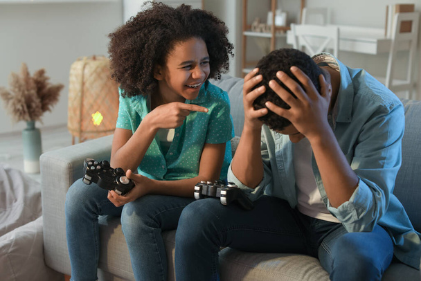 African-American teenagers playing video game at home - Foto, afbeelding