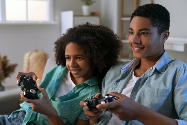 アフリカ系アメリカ人のティーンエイジャーが自宅でビデオゲームをプレイ - 写真・画像