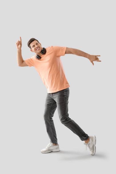 Handsome young man dancing against light background - Foto, immagini