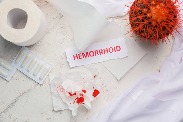 Σύνθεση με κάκτο, χαρτί υγείας και λέξη HEMORRHOID σε ανοιχτό φόντο - Φωτογραφία, εικόνα