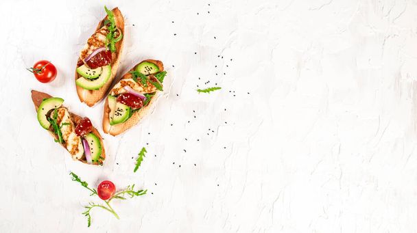 Bruschetta, toasted grilled Halloumi cheese and slices of avocado on white background top view with space for text. Healthy food. Long banner format. - Φωτογραφία, εικόνα