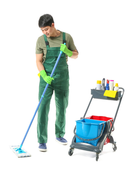 Male janitor with cleaning supplies on white background - 写真・画像