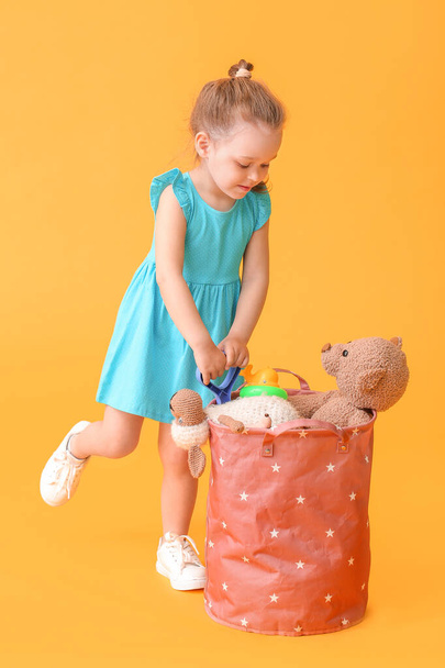 Little girl with toys on color background - Photo, Image