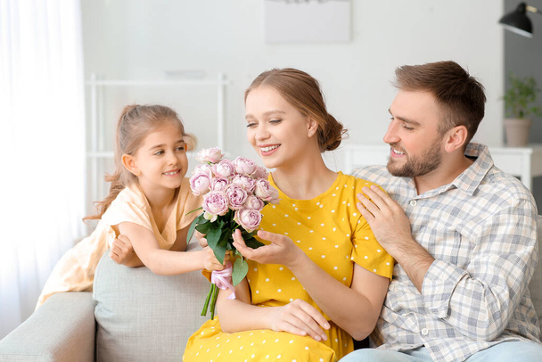 Little girl giving bouquet of flowers for her mother at home - Фото, изображение