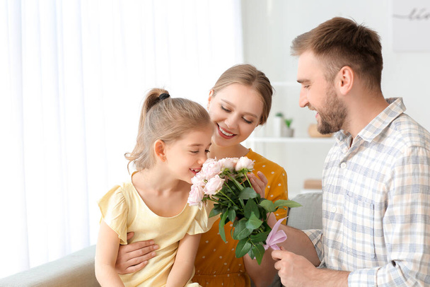 Мужчина дарит букет цветов своей жене и дочери дома
 - Фото, изображение