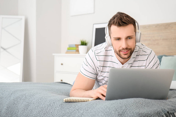 Young man with laptop working at home - Photo, Image