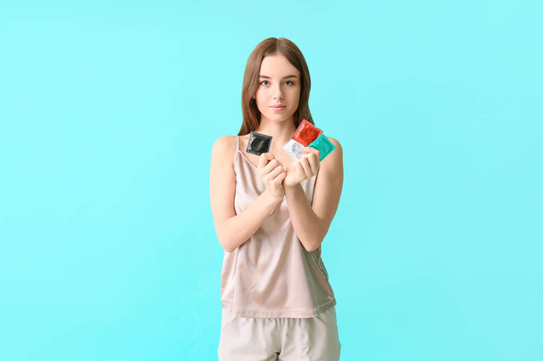 Fiatal nő óvszerrel színes háttér - Fotó, kép