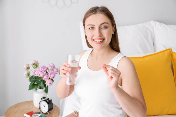 Mladá žena užívat antikoncepci pilulky doma - Fotografie, Obrázek