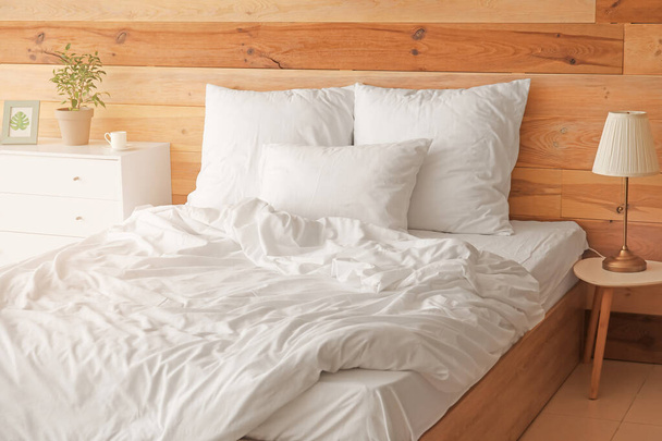 Cama grande e confortável com roupa de cama limpa no quarto
 - Foto, Imagem