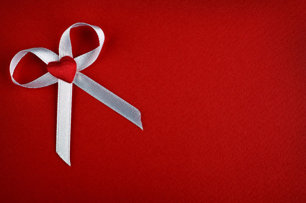Arc blanc avec coeur sur fond rouge
 - Photo, image