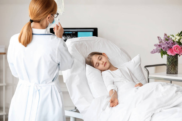 Ärztin arbeitet mit kleinem Mädchen im Krankenhauszimmer - Foto, Bild