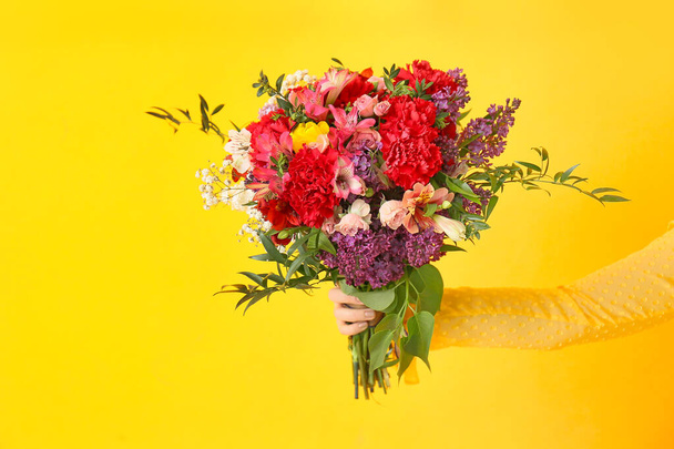 Mano femminile con bellissimo bouquet su sfondo a colori
 - Foto, immagini