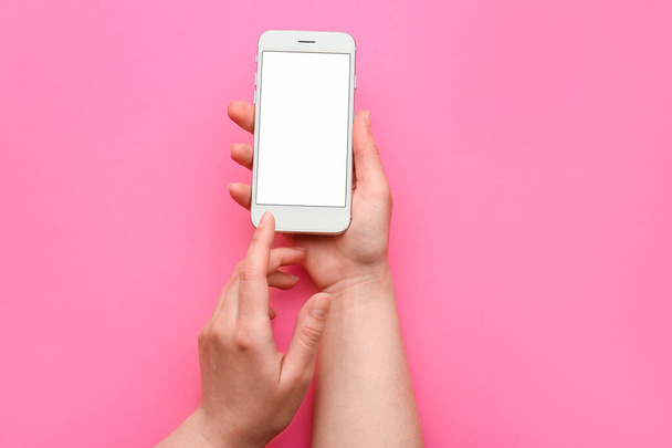 Ženské ruce s mobilním telefonem na barevném pozadí - Fotografie, Obrázek
