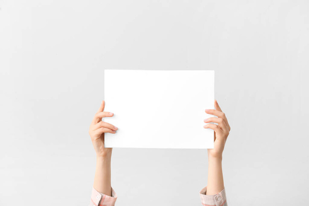Female hands with blank card on light background - Photo, Image