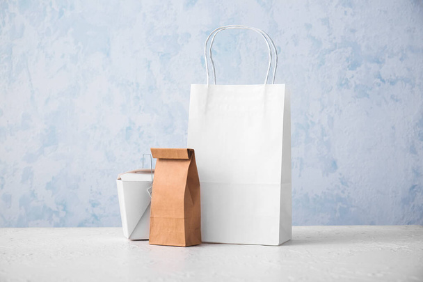 Papírové tašky a krabice na stole na světlém pozadí - Fotografie, Obrázek