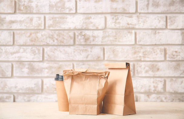 Paper bags and cup of coffee on table - Photo, Image