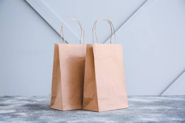 Paper bags on table against light background - Foto, immagini