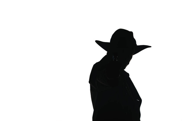 Atractivo joven modelo masculino posando en abrigo largo y sombrero negro, sosteniendo una pistola
 - Foto, imagen